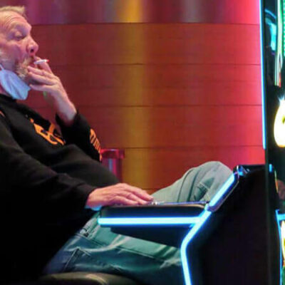 FILE - This Feb. 10, 2022, photo shows a man smoking while playing a slot machine at the Ocean Casino Resort in Atlantic City, N.J. In August 2022, the possibility of casinos creating outdoor smoking areas was being discussed among New Jersey legislators, who have so far not acted on a bill that would ban smoking inside Atlantic City's nine casinos.Wayne Parry/AP