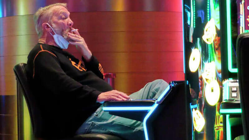 FILE - This Feb. 10, 2022, photo shows a man smoking while playing a slot machine at the Ocean Casino Resort in Atlantic City, N.J. In August 2022, the possibility of casinos creating outdoor smoking areas was being discussed among New Jersey legislators, who have so far not acted on a bill that would ban smoking inside Atlantic City's nine casinos.Wayne Parry/AP