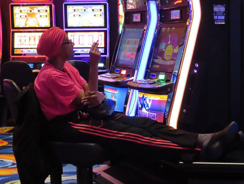 FILE - This Feb. 10, 2022, photo shows a gambler smoking while playing a slot machine at the Ocean Casino Resort in Atlantic City, N.J. In August 2022, the possibility of casinos creating outdoor smoking areas was being discussed among New Jersey legislators, who have so far not acted on a bill that would ban smoking inside Atlantic City's nine casinos.Wayne Parry/AP